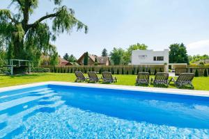 a swimming pool in a yard with lounge chairs at Holiday home in Balatonmariafürdo 38170 in Balatonmáriafürdő