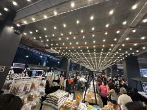 a crowd of people walking around a market with lights at Tropics City Supreme Black Theme Large Balcony City View至尊黑主题大阳台城市风景民宿 in Kuching