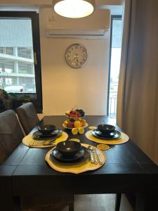a table with plates of food and a clock on the wall at Lemon Studio by the Sea in Saturn