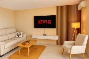 ein Wohnzimmer mit Sofa und Fernseher in der Unterkunft Panoramic Cala Canyelles, Pool in Roses