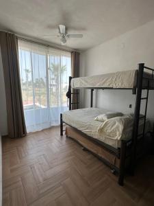 Un dormitorio con una litera y una ventana grande. en House in Teques Rooftop with view and pool for 15, en Tequesquitengo