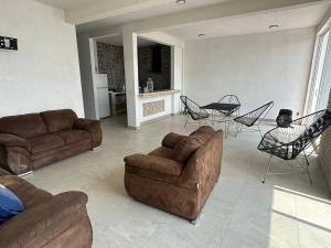 Una sala de estar con sofás y una mesa y sillas. en House in Teques Rooftop with view and pool for 15, en Tequesquitengo