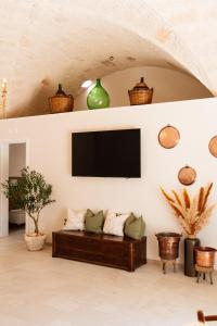 a living room with a couch and a tv on a wall at Oasi di pace in Montalbano