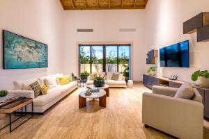 a living room with white furniture and a large window at Casa Ceiba in La Romana