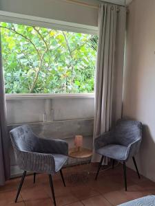 two chairs and a table in front of a window at Studio bord de mer in Schœlcher