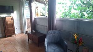 a room with a chair and a desk and a window at Studio bord de mer in Schœlcher