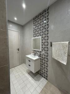 a bathroom with a sink and a tv on the wall at Dar Omi Aïcha in Kerkouene