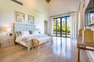 a bedroom with a bed and a large window at Casa Ceiba in La Romana