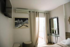 a bedroom with a bed and a window at Hostal Cuevas in Fuengirola