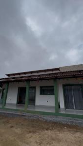 a white and green building with a lot of windows at Suítes Refúgio Serrano in Bananeiras