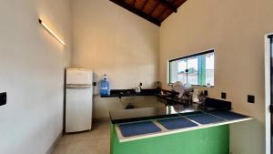 a kitchen with a sink and a refrigerator at Suítes Refúgio Serrano in Bananeiras