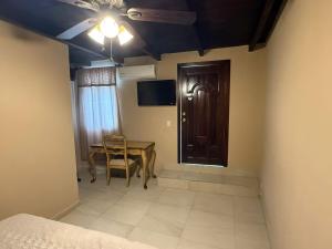 a bedroom with a table and a door and a table and chair at Hotel Carretas in Jalpan de Serra