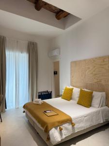 a bedroom with a large white bed with yellow pillows at Tresette Porta Capuana in Naples