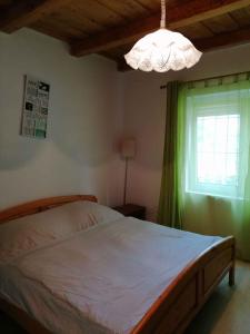 a bedroom with a bed and a window and a chandelier at Holiday home in Balatonbereny 38081 in Balatonberény