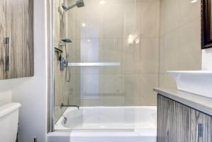 ein Badezimmer mit einer Dusche und einer weißen Badewanne in der Unterkunft Cozy 1 Bedroom Domaine de la Montagne Tremblant in Mont-Tremblant + 27 Fotos
