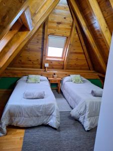 2 letti in una camera in una mansarda in legno di Ostau ERA NHEUADA VALLE DE ARAN ad Aubert