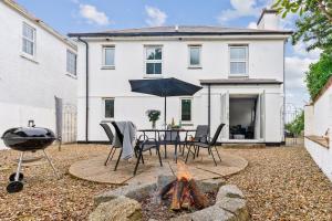 a patio with a table and a fire pit in front of a house at Peaceful house 10 min walk to beach & parking in Falmouth
