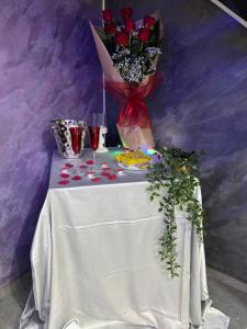 a table with a vase of roses and wine glasses at Il cortiletto28 Rooms & House in Siracusa
