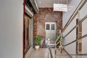 a hallway with a door and a plant at Hotel O Sky Hotel in Rohtak