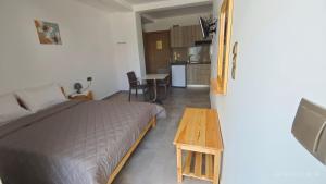 a bedroom with a bed and a table and a kitchen at ΣΤΕΡΓΙΟΥ ΠΑΝΑΓΙΩΤΗΣ studio in Loutra Edipsou