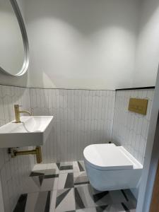a bathroom with a white toilet and a sink at Luxe 2 bed - 20 minutes from Central London in London