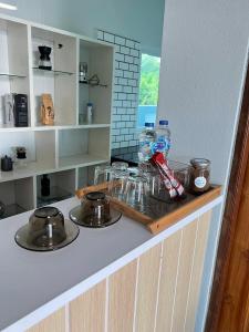 Una encimera de cocina con dos ollas y sartenes encima. en R-Rich Homestay อาริชโฮมสเตย์, en Betong
