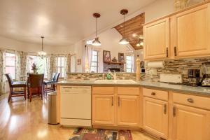 a kitchen with wooden cabinets and a dining room at Unwind Fireside! Home 30 Mi to Sunrise Ski Resort in Pinetop