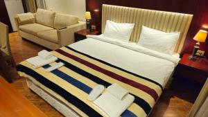 a bedroom with a large bed and a couch at Dreamland Oasis 1 Studio in Chakvi