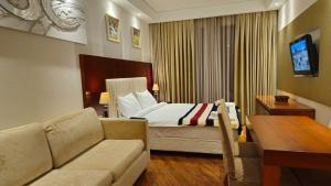a hotel room with a bed and a couch at Dreamland Oasis 1 Studio in Chakvi