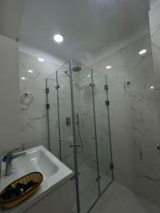 a bathroom with a glass shower and a sink at Athina Rooms in Himare