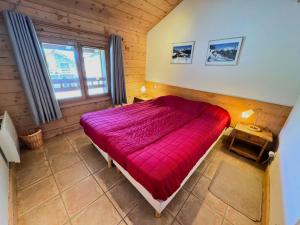 ein Schlafzimmer mit einem roten Bett in einem Holzzimmer in der Unterkunft Les Chalets Du Doron - Bel appartement dans les 3 Vallées MAE-4504 in Praranger