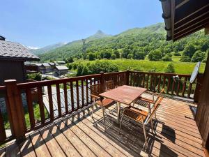 eine Holzterrasse mit einem Tisch und Stühlen darauf in der Unterkunft Les Chalets Du Doron - Bel appartement dans les 3 Vallées MAE-4504 in Praranger