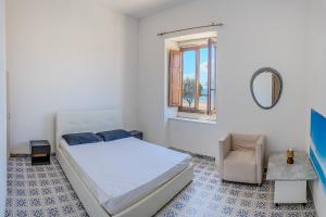 a bedroom with a bed and a chair and a mirror at Casa Mare in Marina di Casalvelino