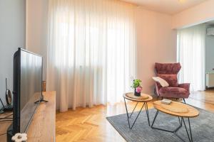 a living room with a tv and a chair and a table at Kuća za odmor GOTA 