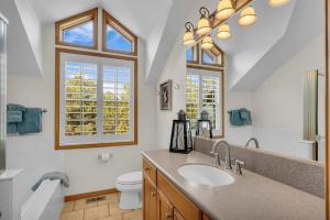 a bathroom with a sink and a toilet and a window at Authentic log cabin minutes from Zion NP in Orderville +32 photos