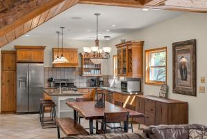 a kitchen with wooden cabinets and a table with chairs at Authentic log cabin minutes from Zion NP in Orderville