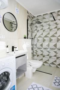 a bathroom with a toilet and a sink and a washing machine at Apartman Castello in Jajce