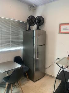 a kitchen with a stainless steel refrigerator in a room at Casa na Prainha com banheira,30m do acesso à praia in São Vicente