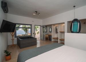 ein Schlafzimmer mit Bett und Flachbildfernseher in der Unterkunft Cape Napos in Faros + 164 Fotos