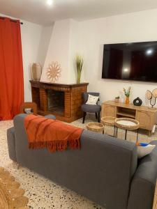 Una sala de estar con un sofá y un televisor. en Casa Lucia, en Aléria