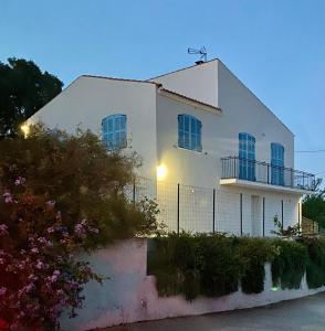 una casa blanca con una valla delante en Casa Lucia, en Aléria