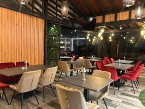 a dining room with tables and red chairs at Hotel San Benito Cuenca in Cuenca