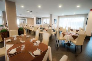 jadalnia ze stołami i białymi krzesłami w obiekcie BNS Hotel Francisco w mieście Baia Domizia