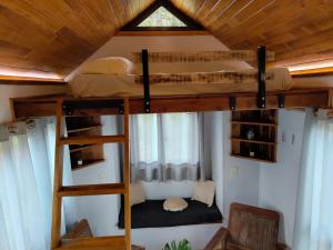 a loft bed in a room with two bunk beds at Tiny House Nativa in Montecarlo