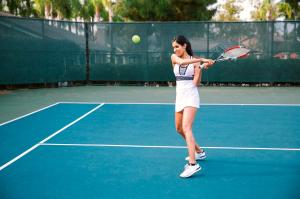 a woman swinging a tennis racket on a tennis court at Agriturismo Mammarella in Altavilla Silentina