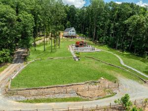 a large green field with a house in the background at Vineyard Cottage in Wine Country with Hot Tub in Jonesville