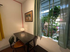 a table and a chair in a room with a window at 88 ngày là tới HOUSE - 88 days to go HOUSE in Da Nang