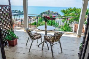 Una mesa y sillas en un balcón con vista al mar. en Apartments Cejovic, en Ulcinj