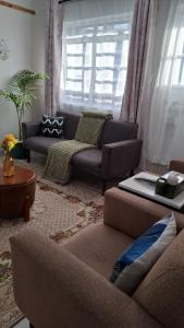 Una sala de estar con dos sofás y una mesa. en Saffron Homes Airstrip A24, en Eldoret