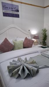 Dos camas blancas con almohadas y un cartel en la pared. en Saffron Homes Airstrip A24, en Eldoret